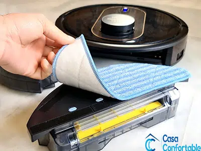 Mopa desmontable levantada para mostrar su fijación al depósito del robot