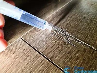Inspección de una hendidura en el parquet antes de repararla