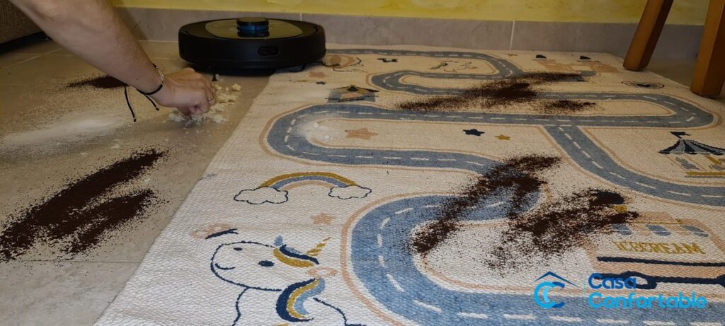Suciedad esparcida sobre una alfombra antes de pasar el Conga 5290 Ultra