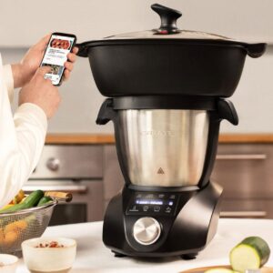 El Chefbot Compact Connect sobre la encimera con la vaporera encima del bol de acero y la app abierta